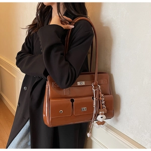 Detailaufnahme der braunen Vintage-Tasche mit zwei Fronttaschen und Hundeanhänger