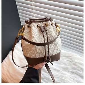 Detailed view of bicolor drawstring bucket bag in textured fleece and brown leather