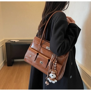 Detail einer braunen Vintage-Einkaufstasche mit zwei Vordertaschen und Hundeanhänger