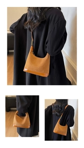 Détail d'un sac hobo en daim marron avec logo embossé et finitions en cuir lisse élégant