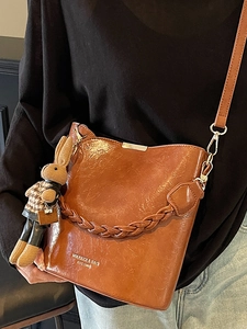 Brown vintage PU leather bucket bag with woven handle and rabbit charm for women
