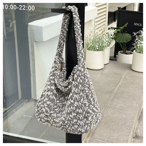 Detail of a large hobo tote bag featuring black and white tweed texture on a shoulder strap