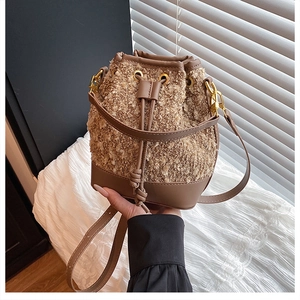 Detail of plush lamb wool bucket bag with premium brown leather base and drawstring closure