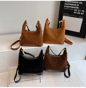 Détail de quatre sacs en daim colorés avec garniture dorée et logo de la marque