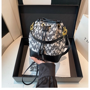 Detail shot of tweed bucket bag inside a premium gift box with gold-tone hardware