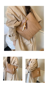 Détail d'un sac cabas tissé marron avec textures verticales et pendentif en perles de bois