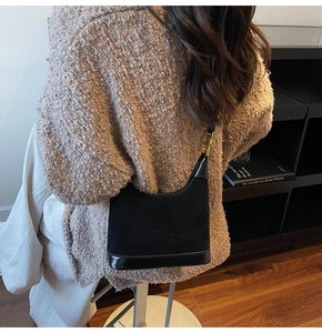 Vue détaillée d'un sac hobo noir avec texture en daim et accents métalliques