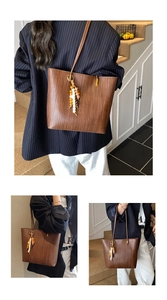 Détail d'un cabas marron tissé avec pompon bohème en perles et finitions en bois naturel