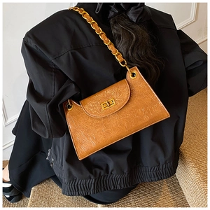 Brown vintage textured faux leather baguette bag with gold chain strap on model