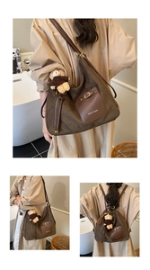 Detailed macro of dark brown suede bag with ZSKE PARIS logo and cute bear charm