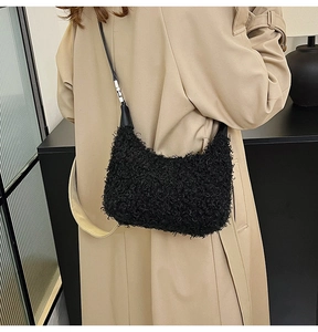 Détail de la texture en peluche noire et boucle argentée sur un sac à bandoulière