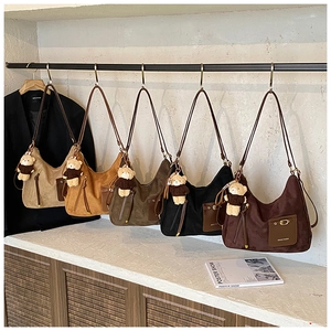 Showcase of five suede crescent shoulder bags in beige, camel, green, black and brown