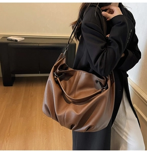 Dettaglio della borsa hobo grande in pelle marrone con grana litchi e tracolla