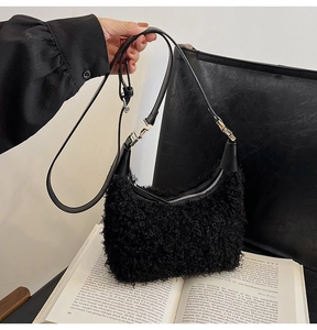 Détail du sac en peluche bouclée noire avec boucles argentées et bandoulière en cuir