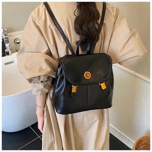 Détail d'un sac à dos en cuir noir avec ferrures dorées et fermoir pivotant chic