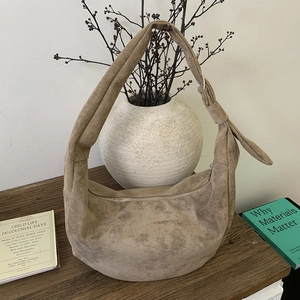 Detail of premium khaki suede dumpling bag showing its soft texture and knotted strap
