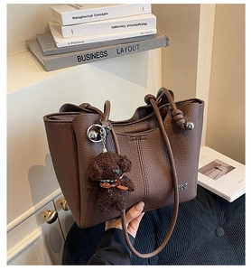 Détail du grand cabas en cuir marron foncé avec poignées nouées et charm de chien