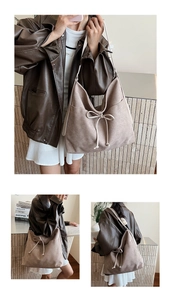 Détail d'un sac cabas vintage en daim marron avec nœud décoratif et large bandoulière