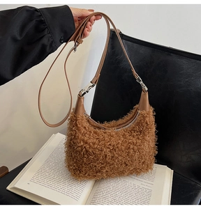 Gros plan du sac lune en peluche marron avec bandoulière en cuir et fermeture éclair