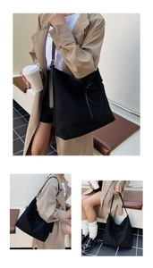 Détail du sac cabas noir avec texture à cordon et nœud porté sur un trench-coat beige