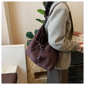 Détail du grand sac cabas en daim marron foncé avec cordon de serrage et longue bandoulière