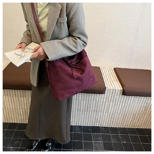 Gros plan du sac cabas bordeaux en suédine avec texture douce et cordon serrage