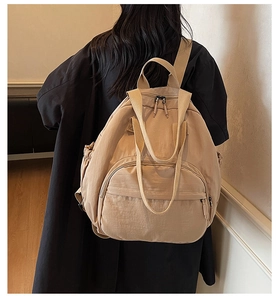 Rear view of khaki large capacity backpack on a model wearing a black winter coat