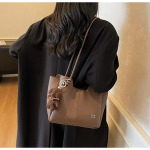 Sac fourre-tout kaki à texture litchi porté à l'épaule avec pendentif ours peluche