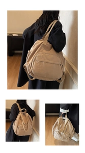 Detailed view of large khaki nylon travel backpack with front zipper and side pocket