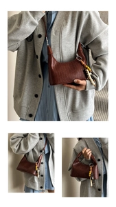 Close-up of dark brown woven leather hobo bag with a colorful beaded tassel charm