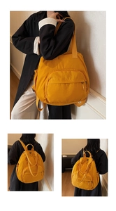 Detail view of a bright yellow nylon backpack featuring large zipper pockets and side mesh