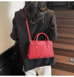 Dettaglio borsa in pelle rossa con motivo a onde ed eleganti finiture in metallo oro