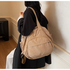 Detail view of khaki nylon large capacity crossbody bag with multiple storage pockets