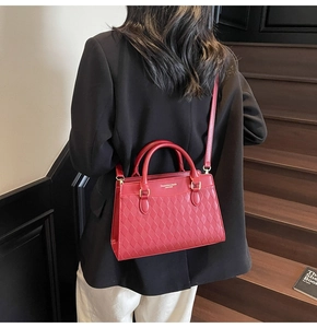 Dettaglio della borsa tote rossa in pelle PU trapuntata con finiture dorate e tracolla