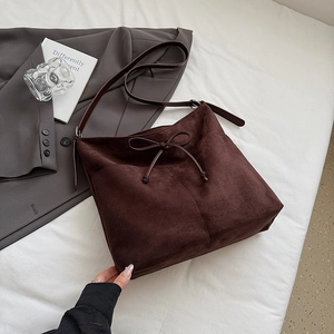 Vue détaillée du cabas en daim marron foncé avec un nœud décoratif et une texture lisse