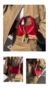 Close-up of red woven leather hobo bag with colorful bead tassel and silver hardware