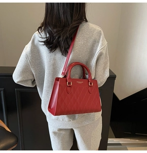 Vista posteriore di una borsa in pelle rossa trapuntata con dettagli dorati