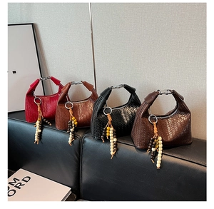 Detail of woven leather handbags in four colors with bohemian style wooden bead charms
