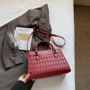 Dettaglio della borsa rossa in pelle PU trapuntata con finiture dorate e scritte moda