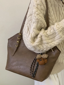 Brown faux leather tote bag with vintage texture and cute teddy bear charm for women