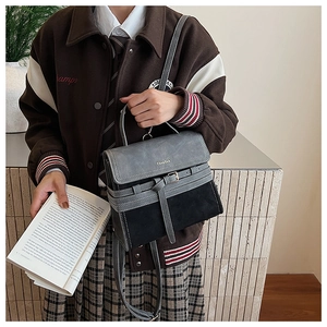 Detail of vintage grey and black satchel featuring top handle and flip-top flap with buckle