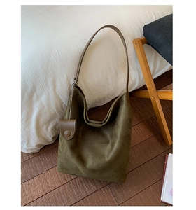 Detailed texture of olive green large suede hobo shoulder bag on wooden floor