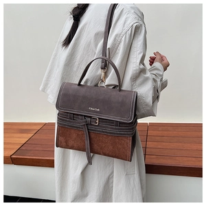 Close-up of vintage leather stitching and metal buckle on the retro crossbody handbag