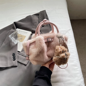 Pink faux fur handbag detail with leather handle and cute brown teddy bear pendant