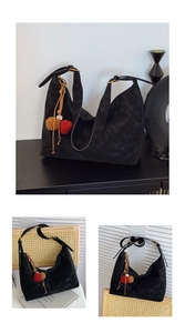 Detail der schwarzen Hobo-Tasche aus Wildleder mit Merfil-Logo und bunten Pompons