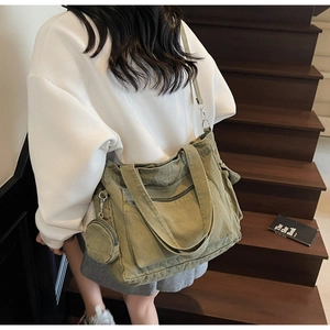 Détail d'un sac cabas en toile vert olive avec petite pochette et boucles en métal