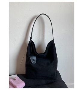 Macro detail of black suede hobo bag with matching mini pouch and slim leather strap