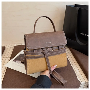 Detail view of vintage tote bag featuring brown leather trim and yellow suede texture