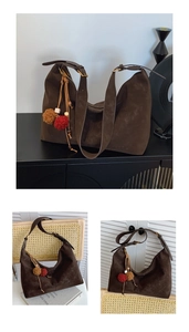 Detailansicht einer braunen Vintage-Wildledertasche mit dekorativem Plüschanhänger