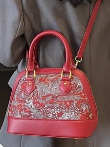 Red shell bag with white floral embroidery and gold hardware for crossbody or hand carry